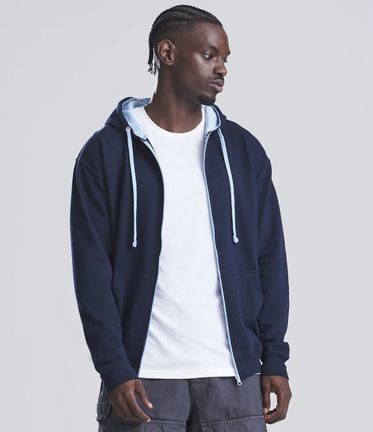 Man wearing a navy blue hoodie over a white shirt on a light gray background