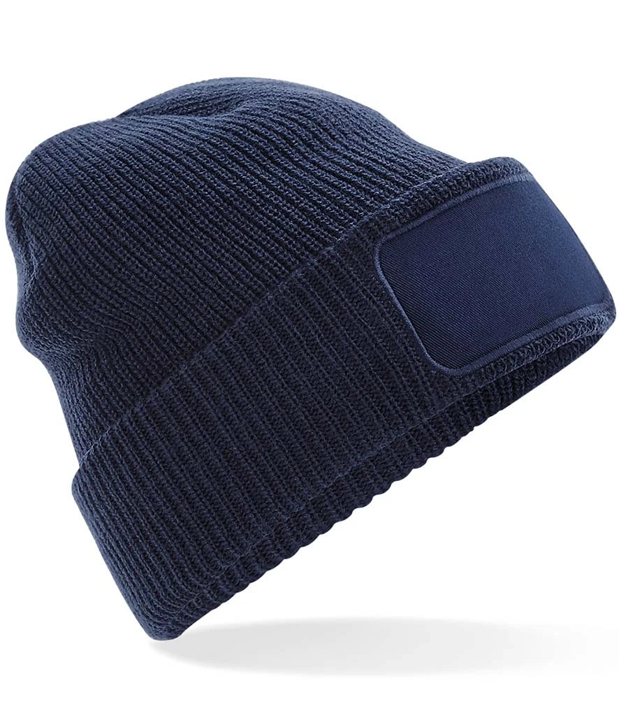 Navy blue knit beanie with a patch on a white background
