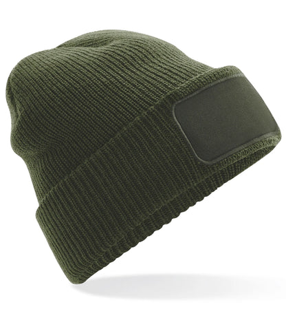 Green knit beanie with a black patch on a white background