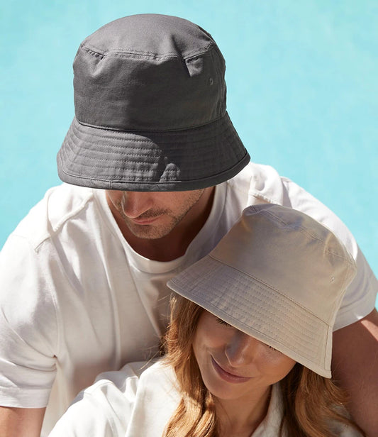 Two people wearing bucket hats against a clear blue sky.