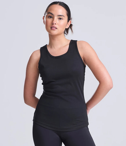 Woman wearing a black tank top against a light gray background
