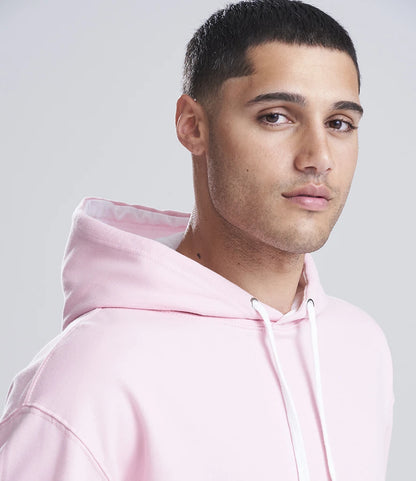 Man wearing a pink hoodie against a light gray background