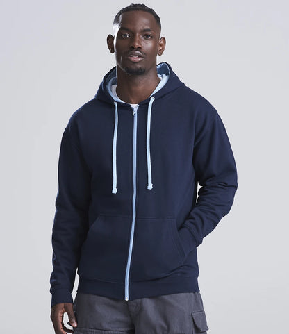 Man wearing a navy blue hoodie with white drawstrings on a light gray background