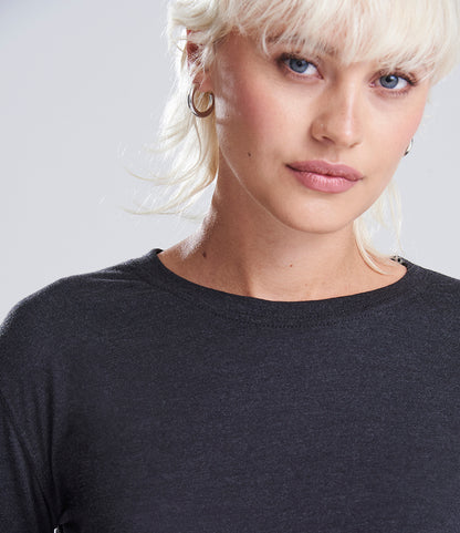 Person with blonde hair wearing a black shirt against a light gray background