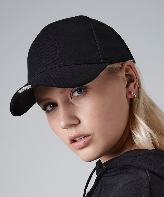 Woman wearing a black cap with light in brim against a gray background 